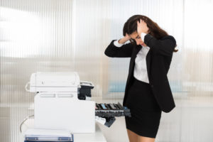 worker-frustrated-by-fax-machine