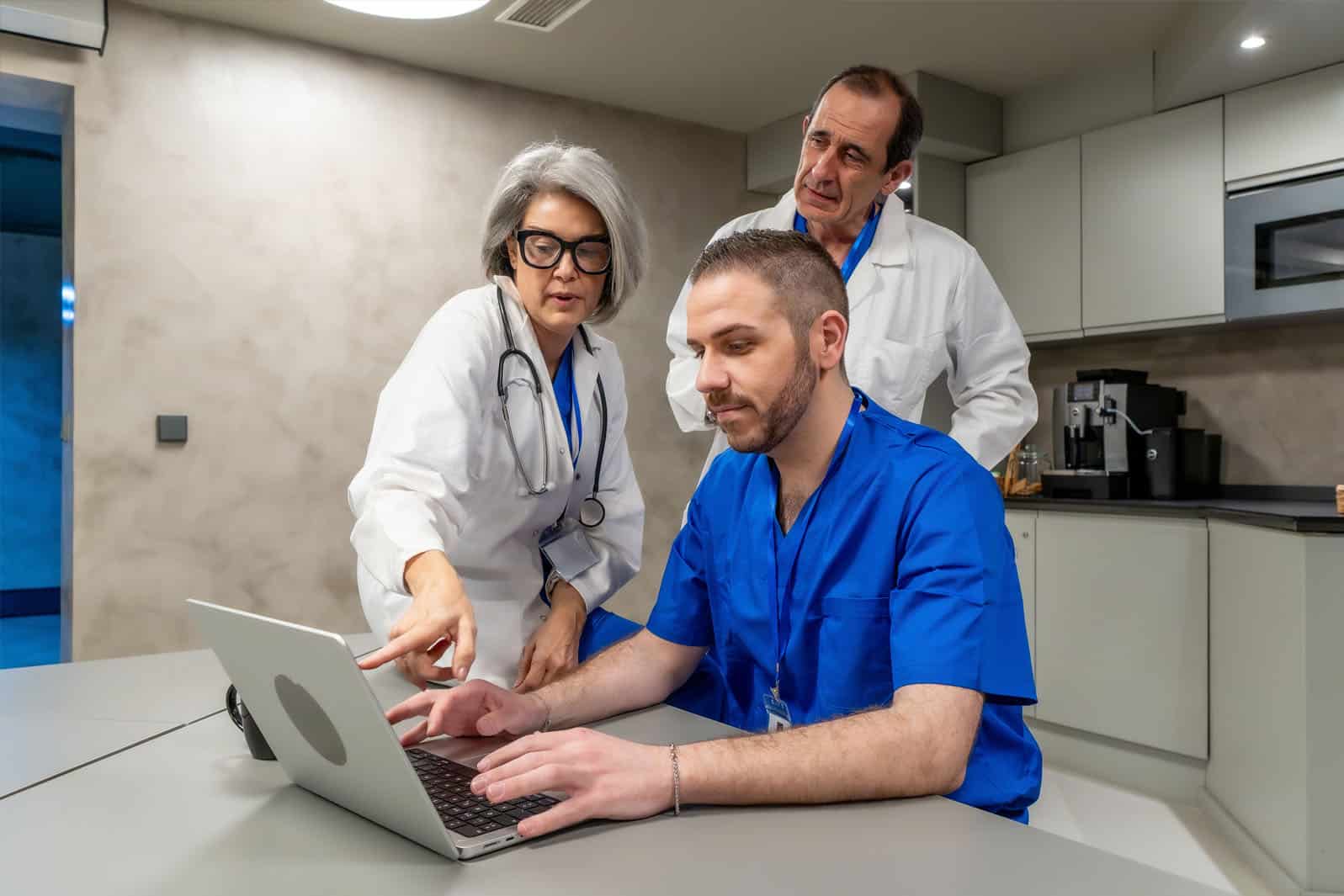 Group of healthcare IT professionals reviewing data on laptop